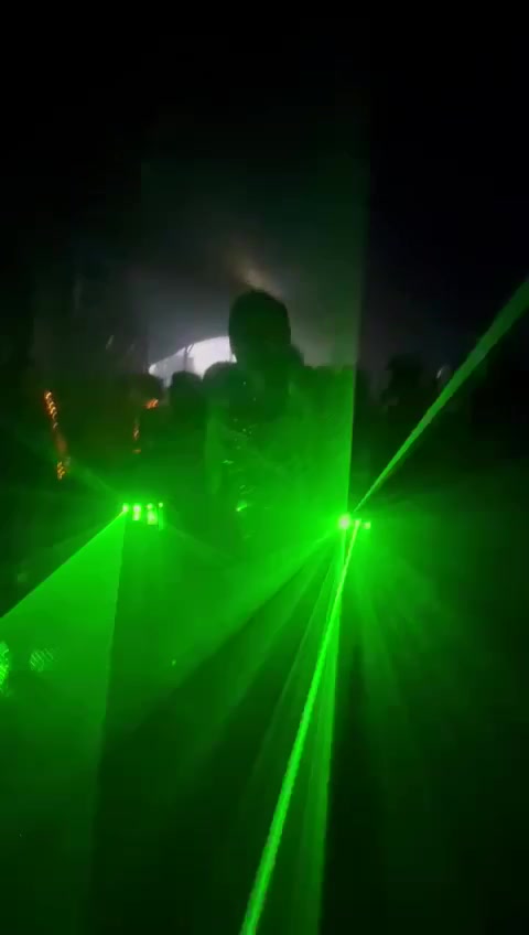 Lumosz als Silhouette im grünen Laserlicht, mitten im Publikum